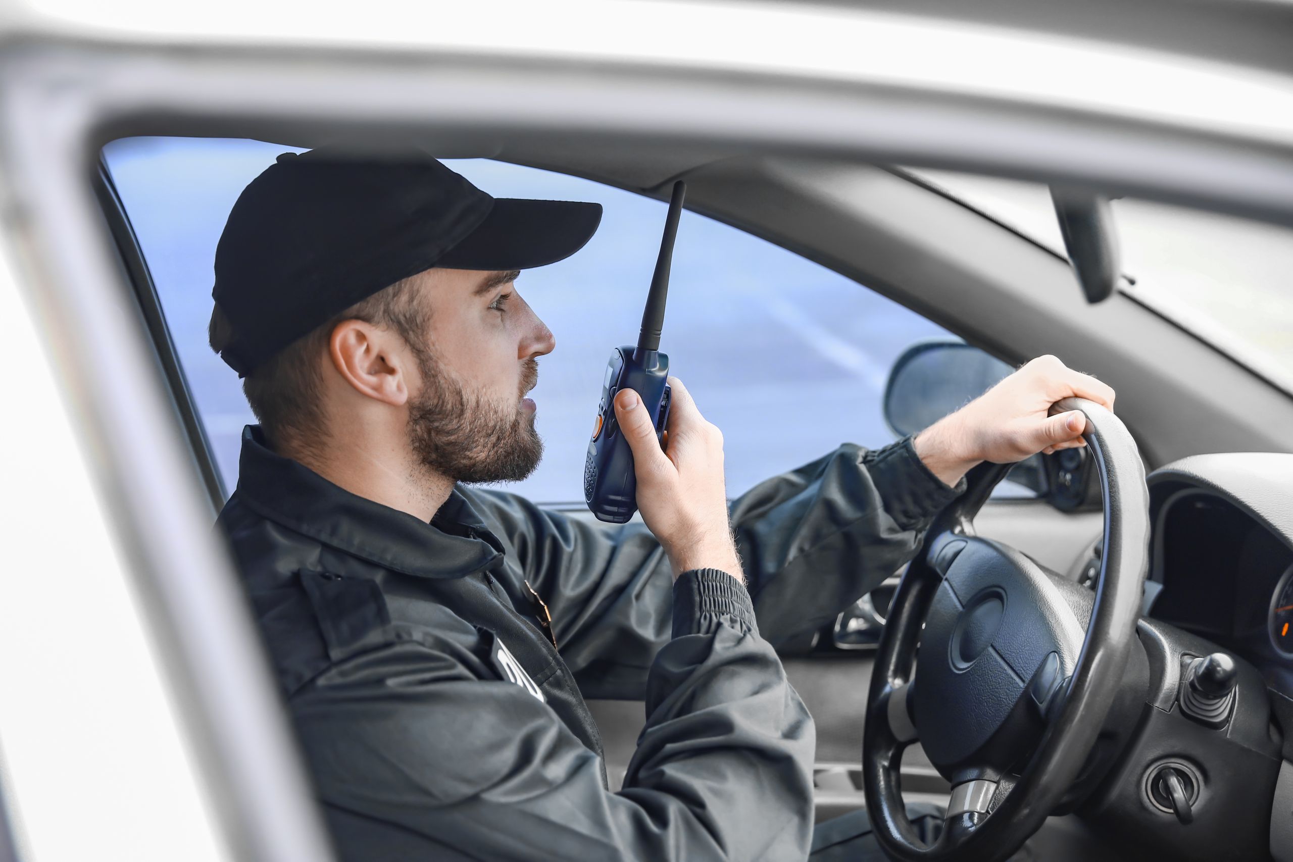 Mann im Auto mit Walkie Talkie